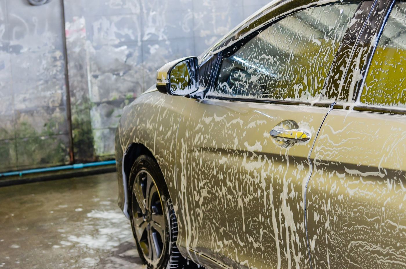 A car covered in wash foam during an exterior detail
